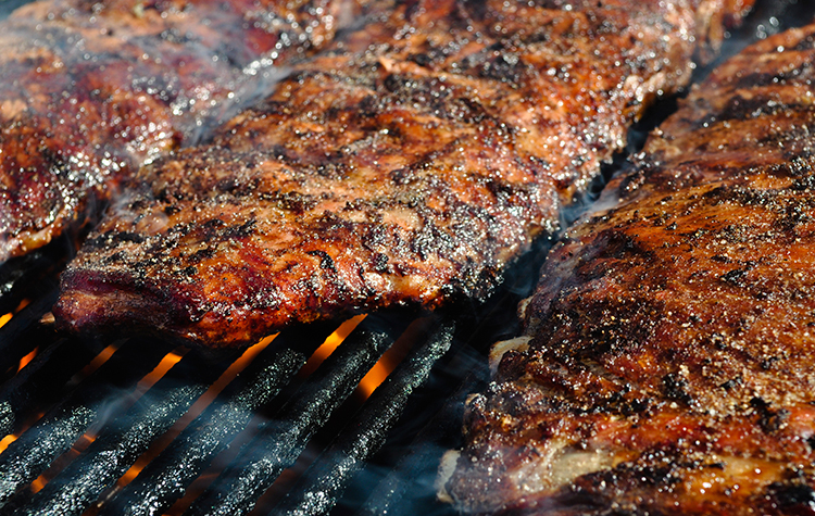 Côtes levées en train de cuire sur les grilles du barbecue